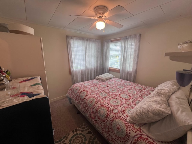 carpeted bedroom featuring baseboards and ceiling fan