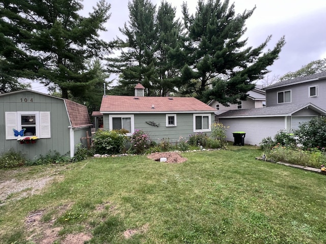 back of property with a yard, a storage shed, an outdoor structure, and a chimney