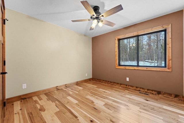 unfurnished room featuring ceiling fan, visible vents, baseboards, and wood finished floors