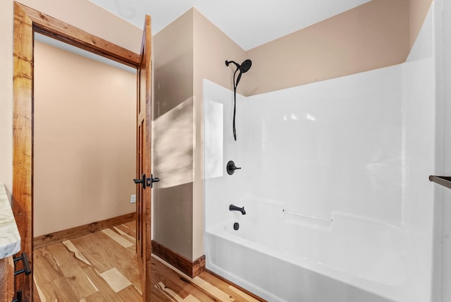 full bathroom featuring bathtub / shower combination, wood finished floors, and baseboards