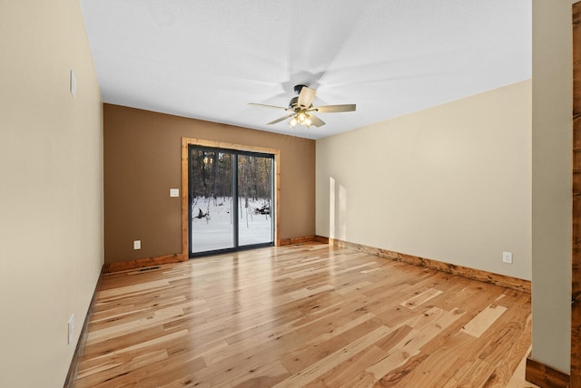 empty room featuring visible vents, light wood-style flooring, baseboards, and ceiling fan