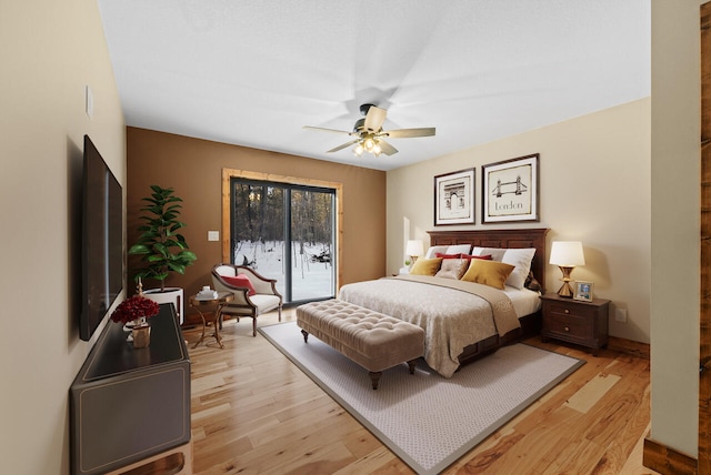 bedroom with access to exterior, light wood-style flooring, and ceiling fan