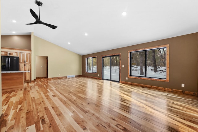 unfurnished living room with visible vents, baseboards, lofted ceiling, recessed lighting, and light wood-type flooring