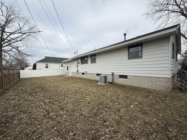 back of property featuring crawl space, central AC, and fence