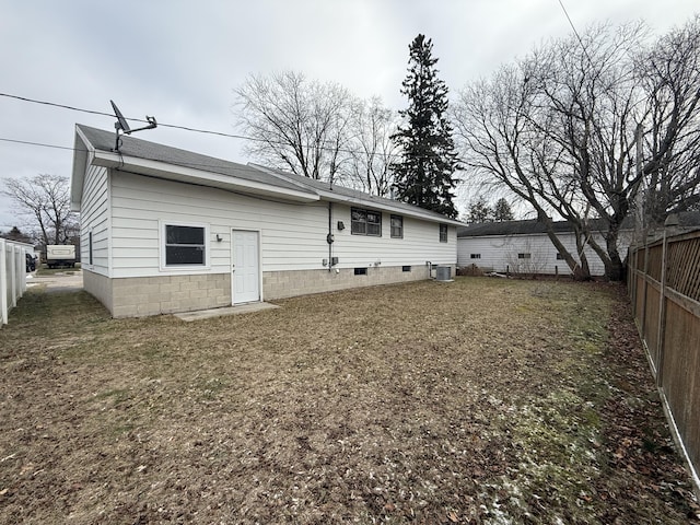 rear view of property with cooling unit, roof with shingles, and fence