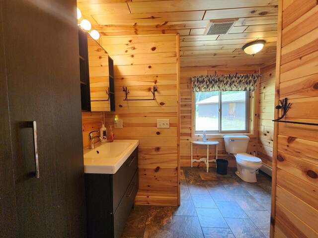 bathroom featuring visible vents, wood walls, toilet, wooden ceiling, and vanity