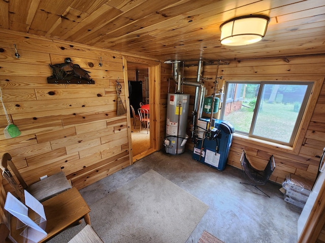 interior space with gas water heater, wooden walls, wooden ceiling, concrete flooring, and a heating unit