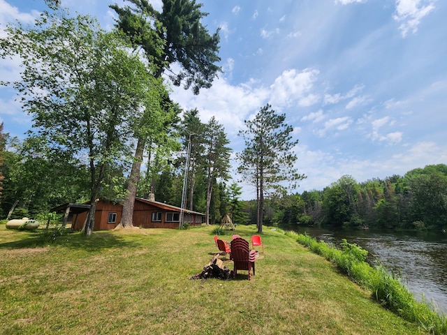 view of yard featuring a forest view and a water view