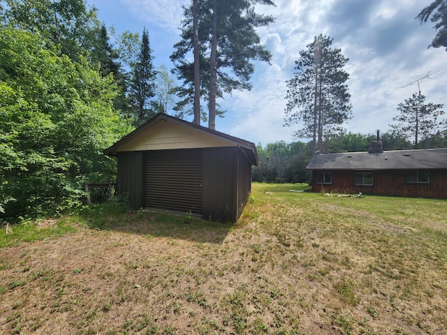 view of yard with an outbuilding, a garage, and driveway