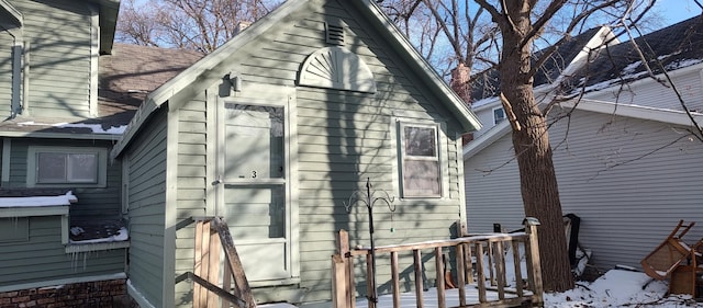 view of property exterior featuring a wooden deck and roof with shingles