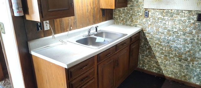 kitchen featuring a sink, brown cabinetry, and light countertops