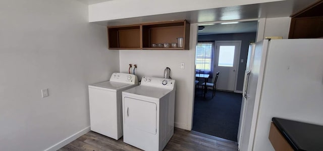 laundry area with cabinet space, wood finished floors, baseboards, and washing machine and clothes dryer