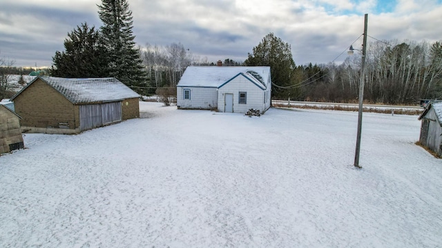 snowy yard featuring an outbuilding