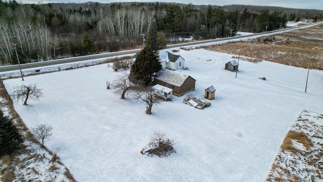 snowy aerial view featuring a forest view