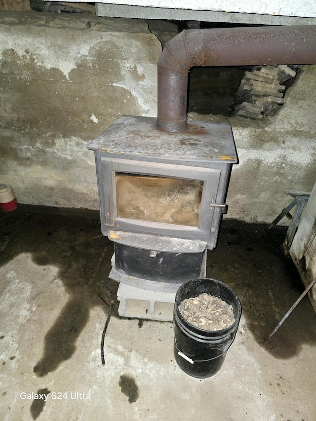 interior details featuring unfinished concrete flooring and a wood stove