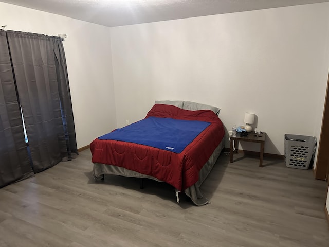 bedroom featuring wood finished floors and baseboards