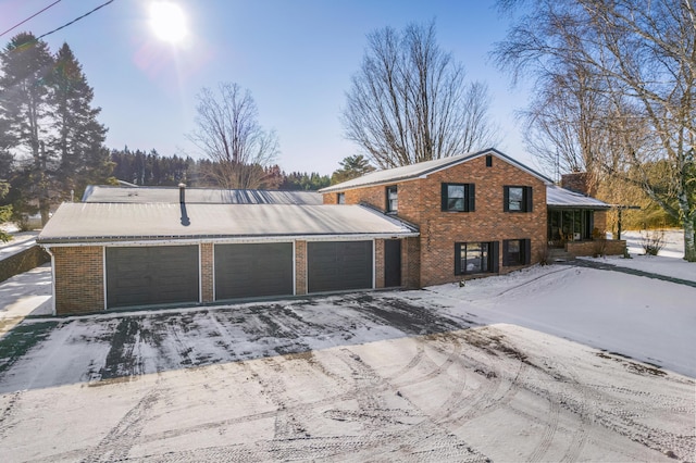 back of property featuring brick siding and an attached garage