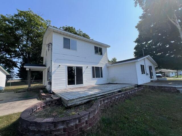 rear view of house featuring a lawn and a wooden deck