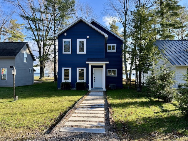 view of front of home with cooling unit and a front yard