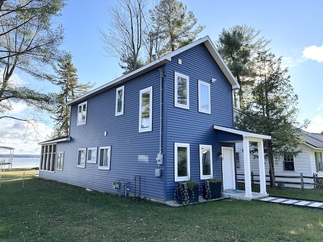 view of front of house featuring a water view, a front lawn, and fence