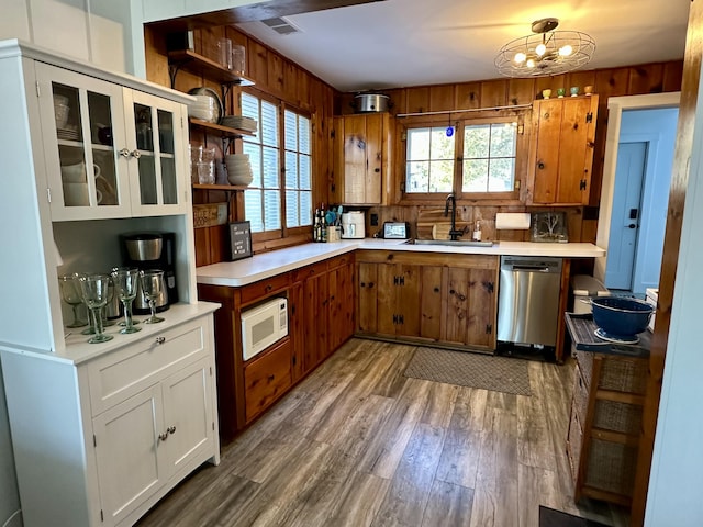 kitchen with stainless steel dishwasher, a healthy amount of sunlight, white microwave, and a sink