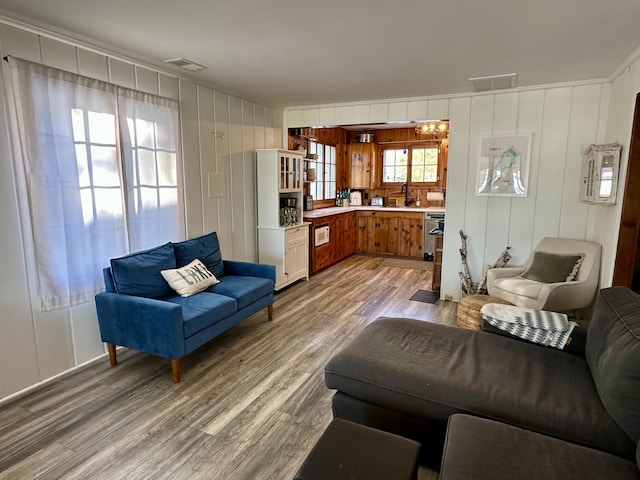 living area with visible vents and wood finished floors