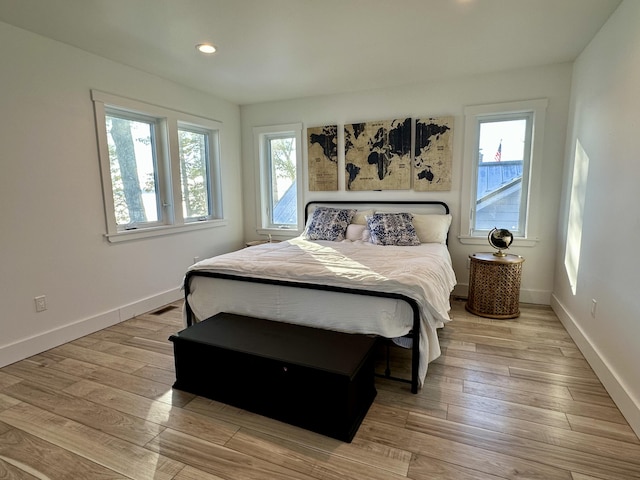 bedroom with recessed lighting, visible vents, baseboards, and wood finished floors