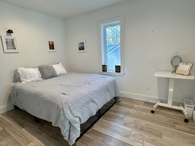 bedroom featuring wood finished floors and baseboards