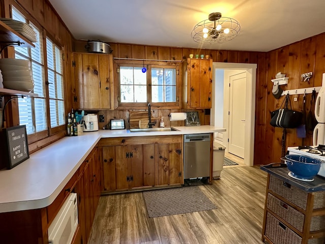 kitchen featuring dishwasher, light countertops, brown cabinetry, and a sink