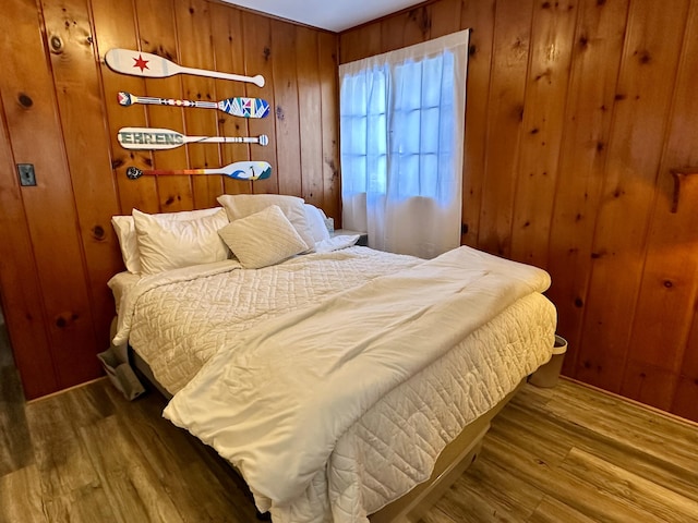 bedroom with wood finished floors and wood walls