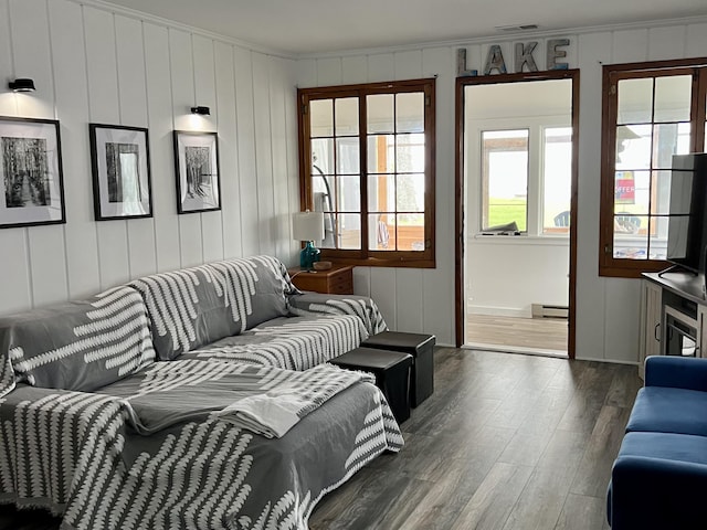 living area featuring crown molding, wood finished floors, visible vents, and a baseboard radiator