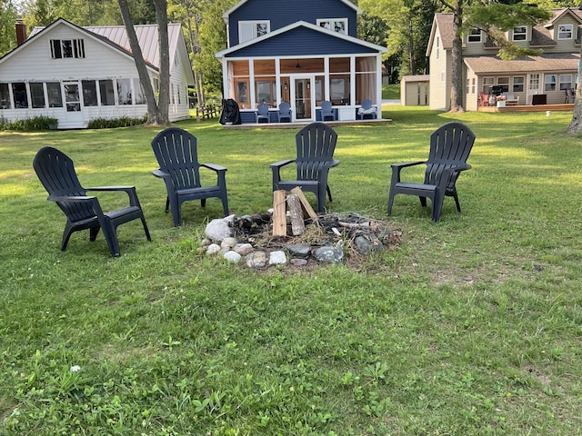 view of yard with a fire pit and a sunroom