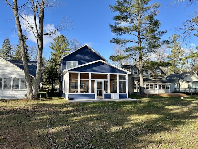 back of property featuring a yard and a sunroom