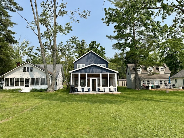 4288 Long Point Dr, Cheboygan, MI 49721 - rear view of house featuring a sunroom and a lawn