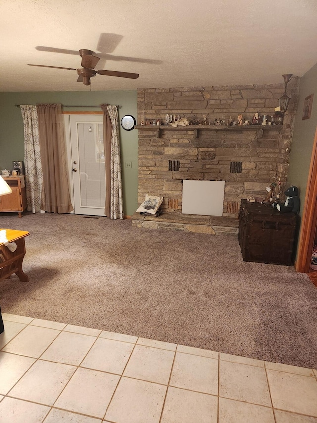 unfurnished living room featuring a textured ceiling, ceiling fan, carpet flooring, and tile patterned flooring