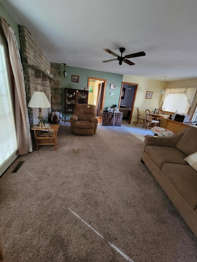 living room featuring visible vents, carpet, and ceiling fan