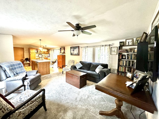 living area with lofted ceiling, a textured ceiling, and ceiling fan