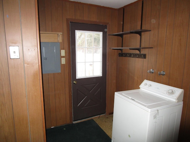 clothes washing area featuring electric panel, washer / clothes dryer, wood walls, and laundry area