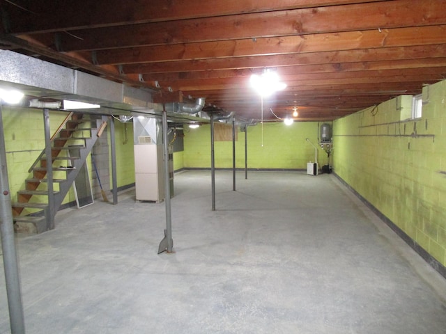 unfinished below grade area featuring stairs and heating unit