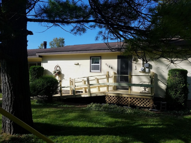 back of house featuring a deck and a yard