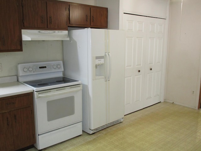 kitchen featuring white appliances, light floors, under cabinet range hood, and light countertops