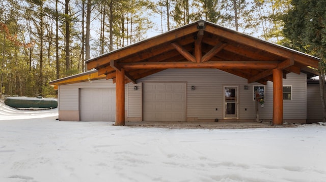 snow covered garage featuring a detached garage