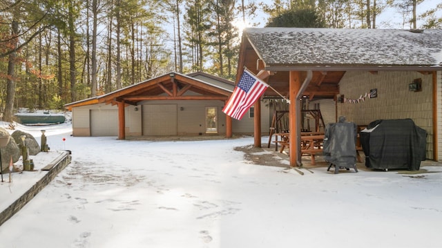 snow covered garage featuring a detached garage