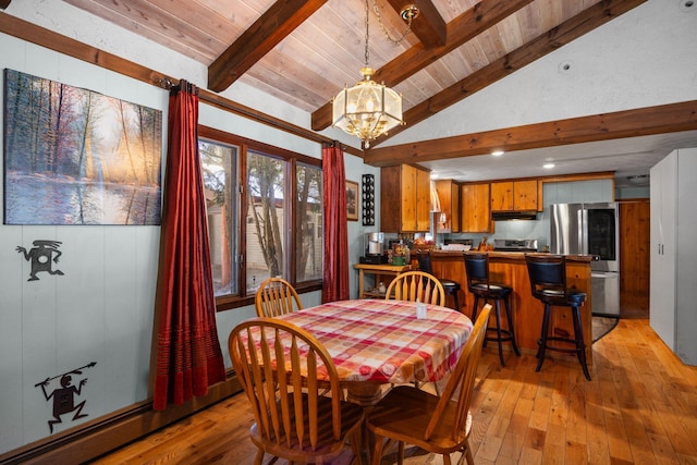 dining area with a notable chandelier, baseboard heating, vaulted ceiling with beams, and light wood finished floors