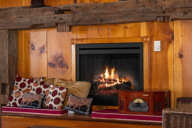 room details featuring wooden walls and a warm lit fireplace