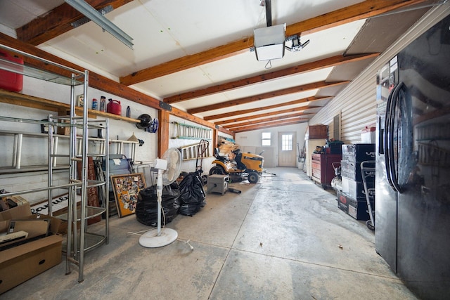 garage with a garage door opener and black fridge