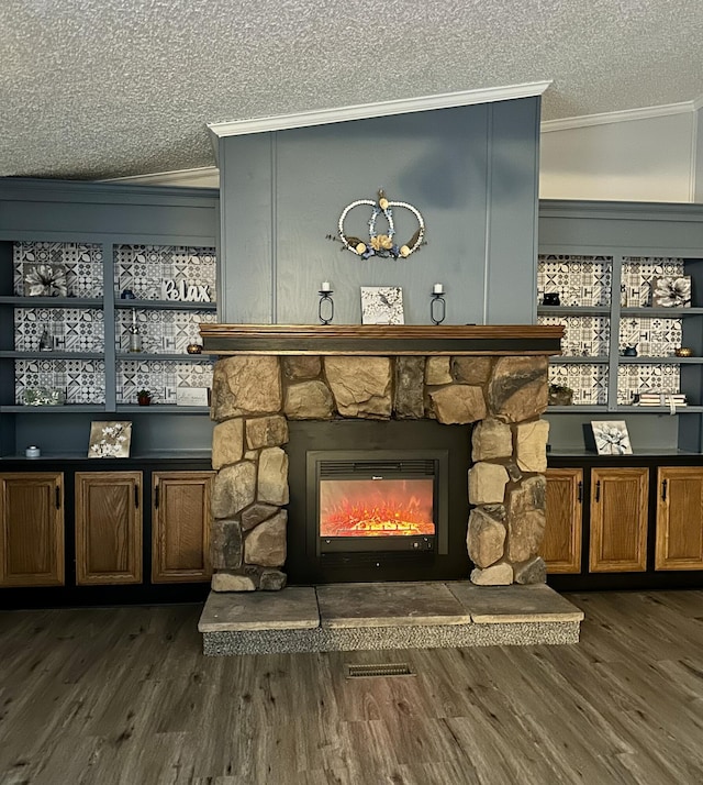 details with a stone fireplace, crown molding, wood finished floors, and a textured ceiling