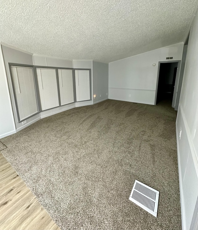 interior space with visible vents, baseboards, a textured ceiling, and carpet flooring