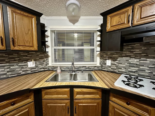 kitchen featuring a sink, open shelves, white gas cooktop, and backsplash