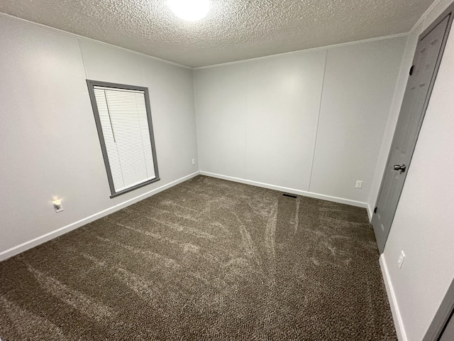 empty room featuring visible vents, a textured ceiling, baseboards, and dark colored carpet